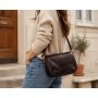 Žena v béžovom svetri a modrých džínsoch s tmavo hnedou talianskou koženou crossbody kabelkou z prav