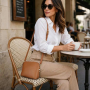 Koňaková talianska kožená crossbody kabelka v letnom outfite – dáma pri káve na terase