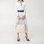 Béžová kožená spoločenská kabelka Wojewodzic z pravej kože pri elegantnom dámskom outfite